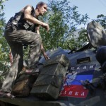 A pro-Russian separatist climbs atop an armoured personnel carrier as he guards a position in the eastern Ukrainian town of Ilovaysk